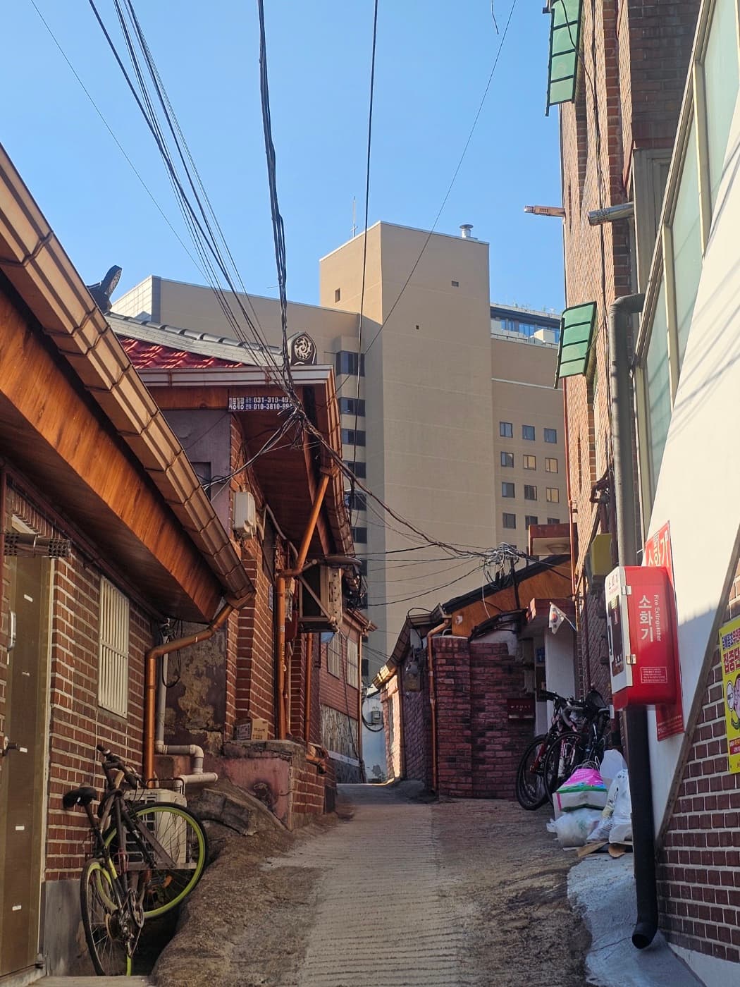 A quiet Seoul alley lined with low-rise buildings, a local corner of the city
